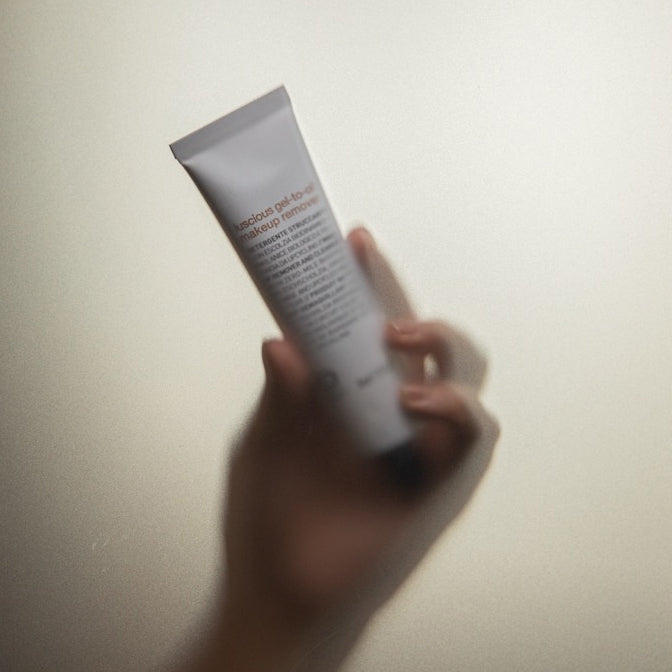 A hand holding an Oway aluminium tube