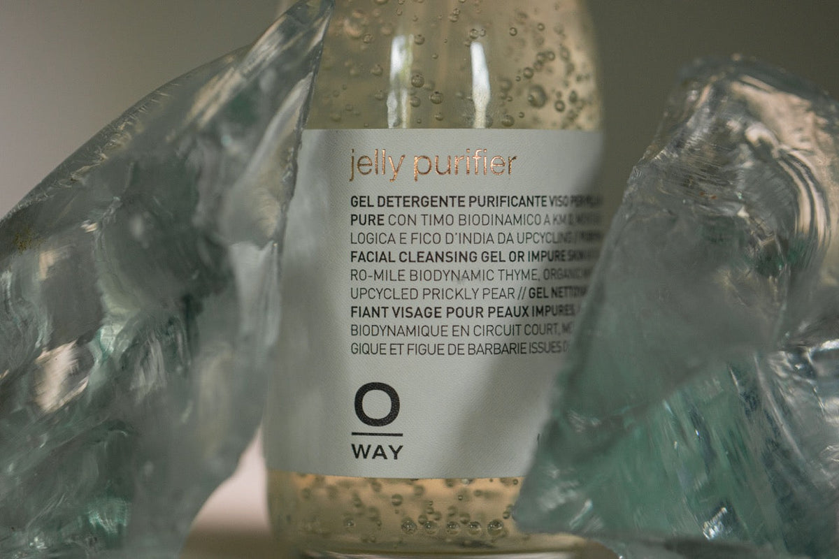 Oway jelly purifier in its glass bottle, among pieces of glass